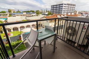 a table and chairs on a balcony with a view of a city at Aligned Corporate Residences Mackay in Mackay