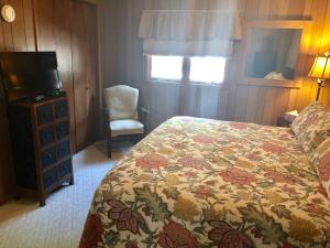 a bedroom with a bed and a television and a chair at Galena Penthouse overlooking Main Street with FREE off street parking in Galena