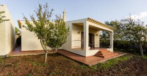 a small house with a porch and a tree at Horta Nova in Lagos