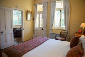 a bedroom with a bed and two windows at Hillview Heritage Estate in Sutton Forest