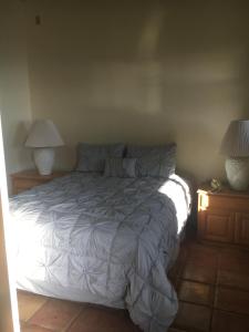 a bed in a bedroom with two night stands and two lamps at Holualoa bungalow 1 in Kailua-Kona