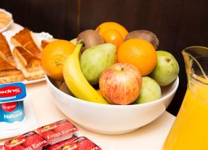 a bowl of fruit with apples oranges and other fruits at Hospedium Hotel Posada De La Luna in Huesca