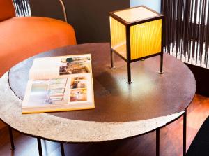 a table with a lamp and a magazine on it at Hospedium Hotel Posada De La Luna in Huesca