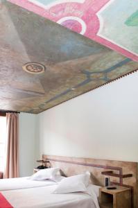 a bedroom with a painting on the ceiling at Hospedium Hotel Posada De La Luna in Huesca