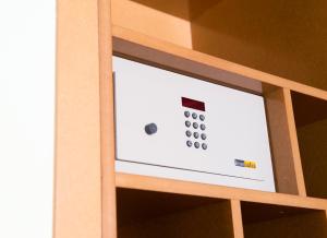 a screen in a wooden cabinet with a remote control at Hospedium Hotel Posada De La Luna in Huesca