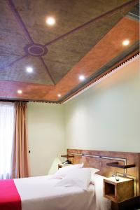 1 dormitorio con 2 camas y techo en Hospedium Hotel Posada De La Luna, en Huesca
