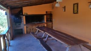 a wooden bench in a room with a flat screen tv at Estrella del Alma in Capilla del Monte