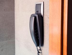 a black phone is hanging on a wall at Hospedium Hotel Posada De La Luna in Huesca