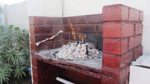 a brick fireplace with a fire in it at Oceanic Playa La Serena in La Serena