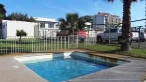 a small swimming pool in a yard with a fence at Oceanic Playa La Serena in La Serena