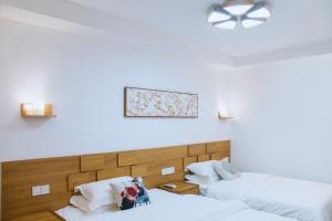 a bedroom with two beds and a picture on the wall at Zhangjiajie Tingyutang Little Yard in Zhangjiajie