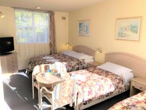 A bed or beds in a room at The Clarendon Motel Katoomba