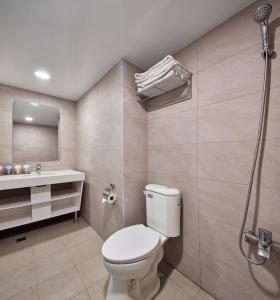 uma casa de banho com um WC, um lavatório e um chuveiro em Kenting City Gate Hotel em Hengchun South Gate