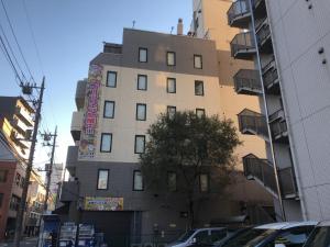 ein hohes Gebäude mit einem Schild an der Seite in der Unterkunft Gomax (Adult Only) in Yokohama