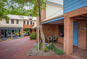 ein Backsteingebäude mit einer blauen Tür und einem Baum in der Unterkunft Middleton Beach by the BnB Collection in Albany