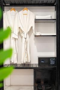 a closet with two white shirts and a microwave at Popular Hotel & Spa in Siem Reap