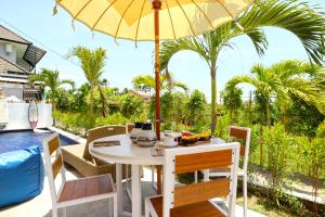 a table that has a umbrella on top of it at Margarita Surf Hostel in Canggu