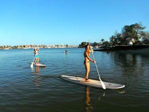 
a woman standing on a surfboard in the water at Beach Hostel Mooloolaba in Mooloolaba
