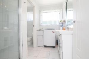 a white bathroom with a sink and a shower at 112 Olive Apartments in Mildura