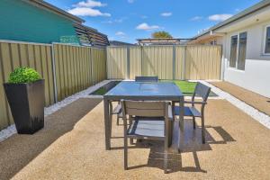 a patio with a table and chairs and a fence at 112 Olive Apartments in Mildura