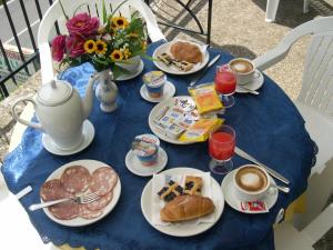 una mesa azul cubierta con platos de comida y café en Hotel Sangallo B&B, en Montepulciano