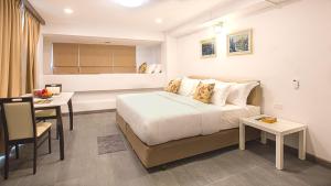 a bedroom with a bed and a table and a desk at V One Pride-Sukhumvit 22, Bangkok in Bangkok