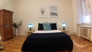 ブダペストにあるOpera Dream Apartmentのベッドルーム1室(ベッド1台、ランプ2つ、テーブル2台付)