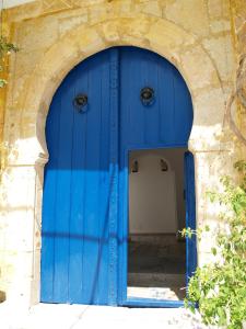 an archway with a blue door in a building at Dar Fatma in Sidi Bou Saïd