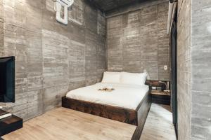 a small bedroom with a bed and a tv at Enishi Resort Villa in Huxi