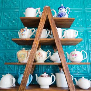 una estantería de madera llena de tazas y teteras en The Delight Swakopmund, en Swakopmund