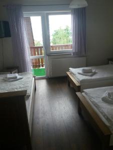 a room with two beds and a large window at Agroturystyka u Barana in Sosnówka