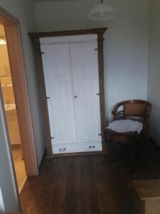 Cette chambre comprend une armoire blanche et une chaise. dans l'établissement Agroturystyka u Barana, à Sosnówka