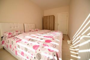 een slaapkamer met een bed met een roze en wit dekbed bij Serenity Apart in Kırklareli