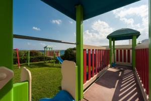 a playground with a slide and swings at Saint George Hotel in Chrissi Akti