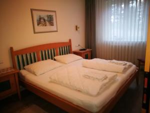 a bedroom with a bed with white sheets and a window at Dünenpark in Binz für Eltern und Kind in Binz