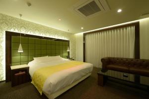 a bedroom with a large bed and a couch at Hotel 5stars (Adult Only) in Takamatsu