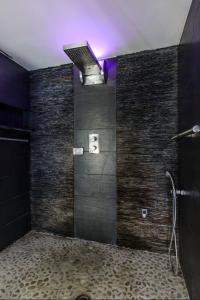 baño con ducha y pared negra en luxury suite San Carlo, en Nápoles