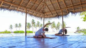 a couple of people doing yoga on the beach at Kitesurfing Lanka in Kalpitiya