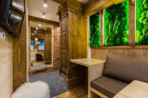 Cette chambre est dotée d'un mur vert avec un banc et une table. dans l'établissement Apartamenty Szymaszkowa, à Zakopane