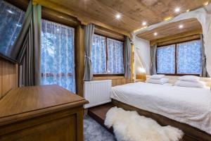 um quarto com uma cama, uma secretária e janelas em Apartamenty Szymaszkowa em Zakopane