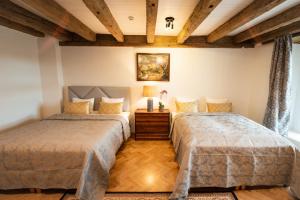 deux lits dans une chambre avec plafonds en bois dans l'établissement Tallinn City Apartments Luxury 4 bedroom with terrace and sauna, à Tallinn