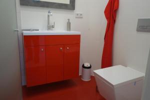 a red bathroom with a sink and a toilet at Kastanienallee 7 in Hamburg
