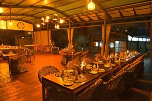 a long table in a restaurant with candles on it at Zambezi Mubala Lodge in Katima Mulilo