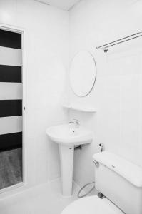 une salle de bain blanche avec un lavabo et un miroir dans l'établissement Crystal Hotel Hua Hin, à Hua Hin 28 autres photos