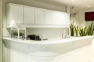 a white kitchen with white cabinets and plants at Crystal Hotel Hua Hin in Hua Hin +27 photos