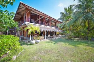 een huis met een balkon en palmbomen bij Kitesurfing Lanka in Kalpitiya