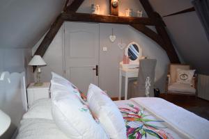 1 dormitorio con cama blanca y almohadas blancas en CATHERINE & DOMINIQUE, en Marigné-Laillé
