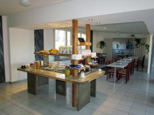a restaurant with a counter and tables and chairs at Fleninge Classic Motel in Fleninge