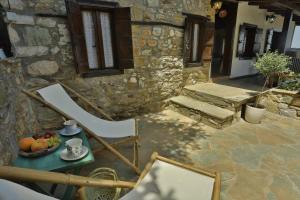 a table with a bowl of fruit and a chair on a patio at Agkaze in Palaios Panteleimon