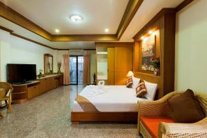 a hotel room with a bed and a television at Royal Prince Residence in Patong Beach